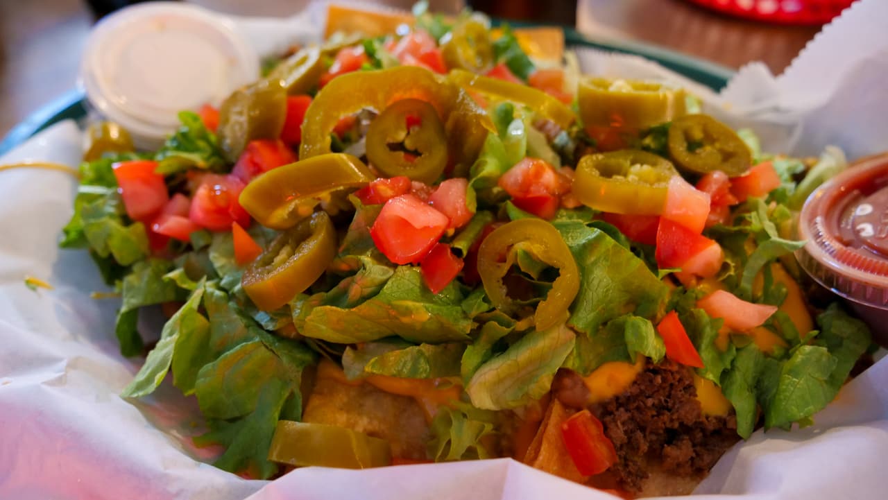 Loaded nachos basket with jalapeños, tomato and lettuce