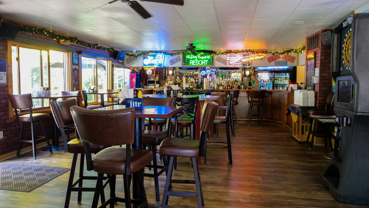 Inside the bar: high-top tables, stools and the lake through the windows