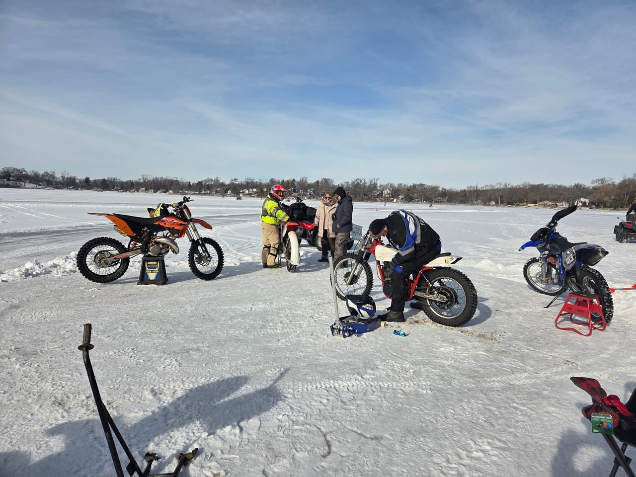 Riders working on their bikes in the pits on the ice