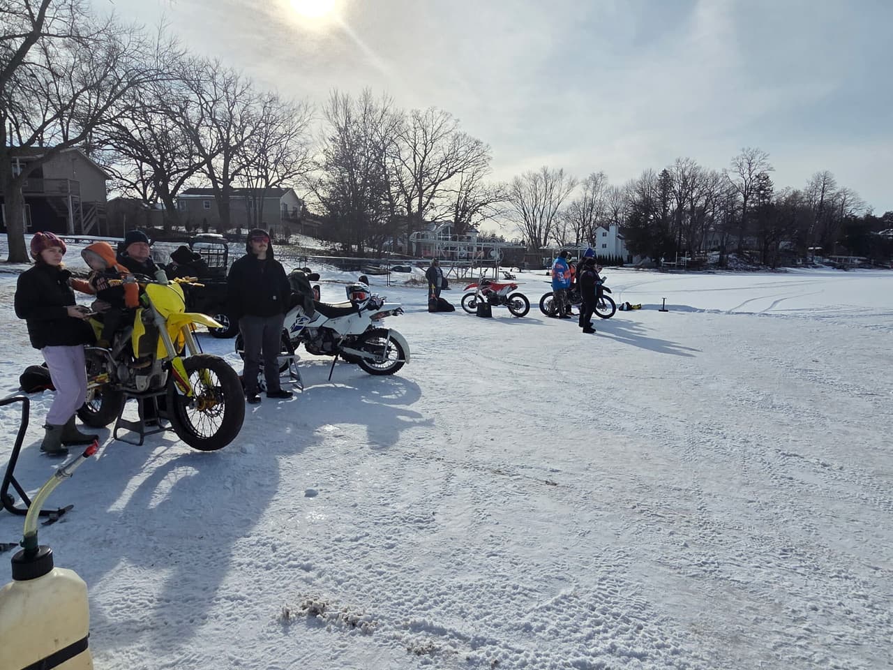 Racers and their bikes lined up on the frozen lake on a sunny winter morning