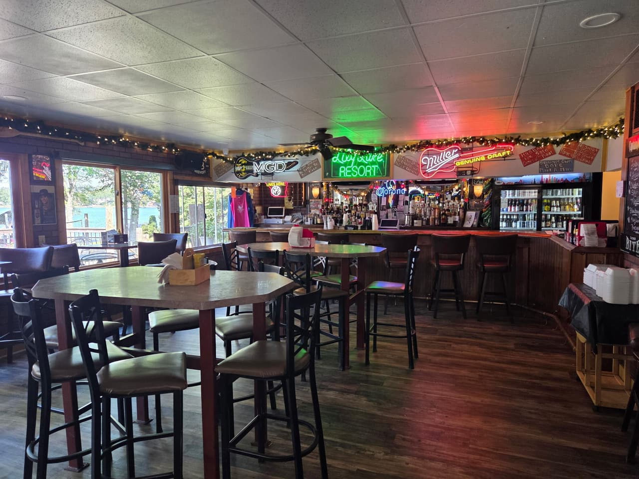 The bar with high-top tables and the green neon Lily Lake Resort sign