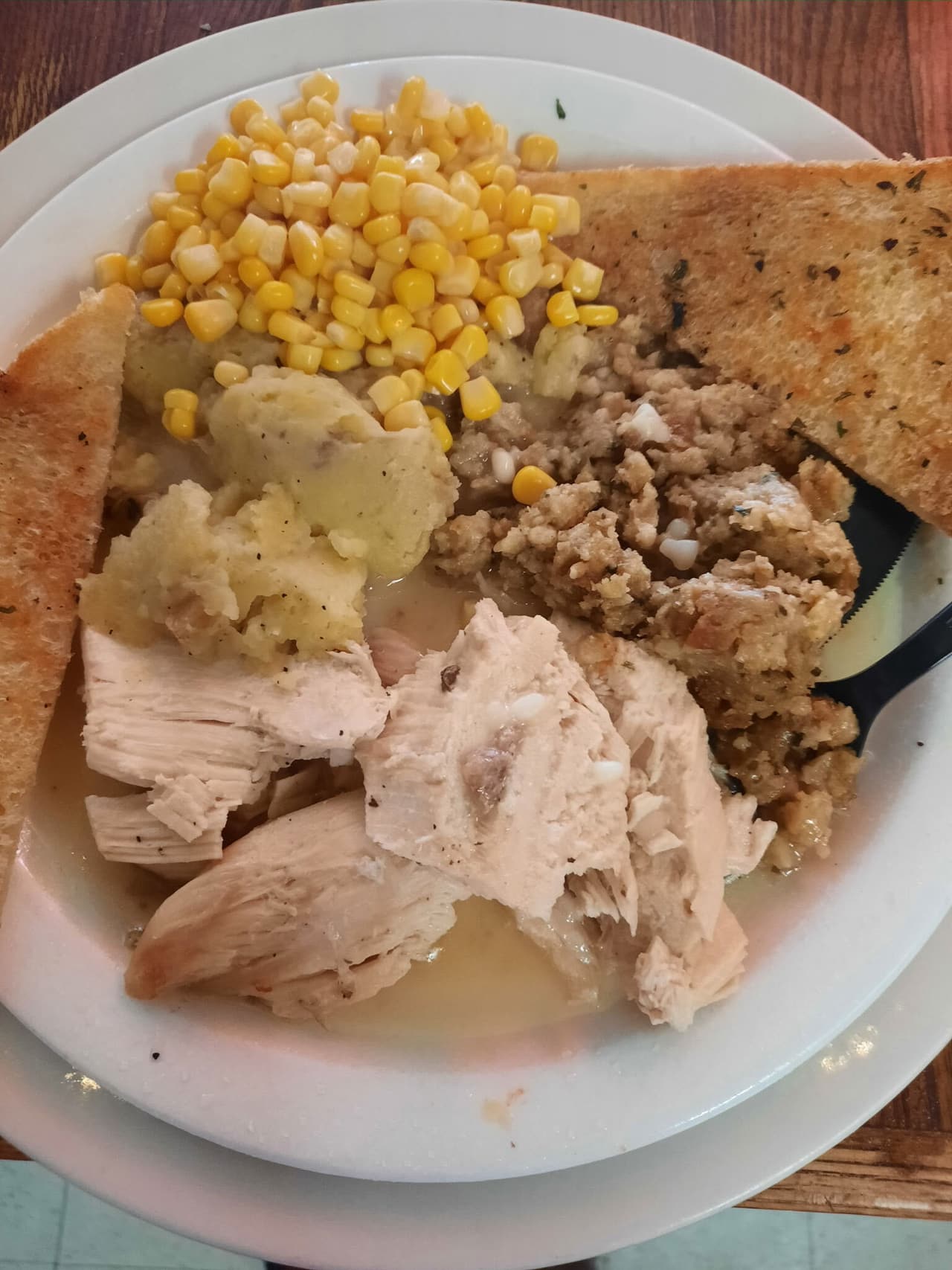 Turkey dinner with stuffing, mashed potatoes, corn and garlic toast