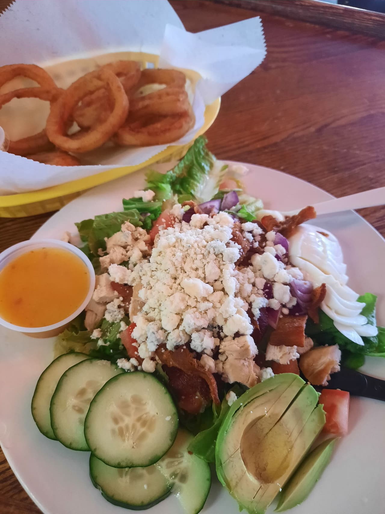 Lily Lake Salad with avocado, blue cheese, bacon and egg, and a basket of onion rings