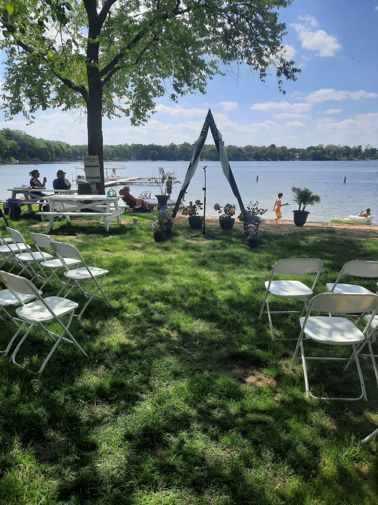 White chairs set up on the lawn facing the lake