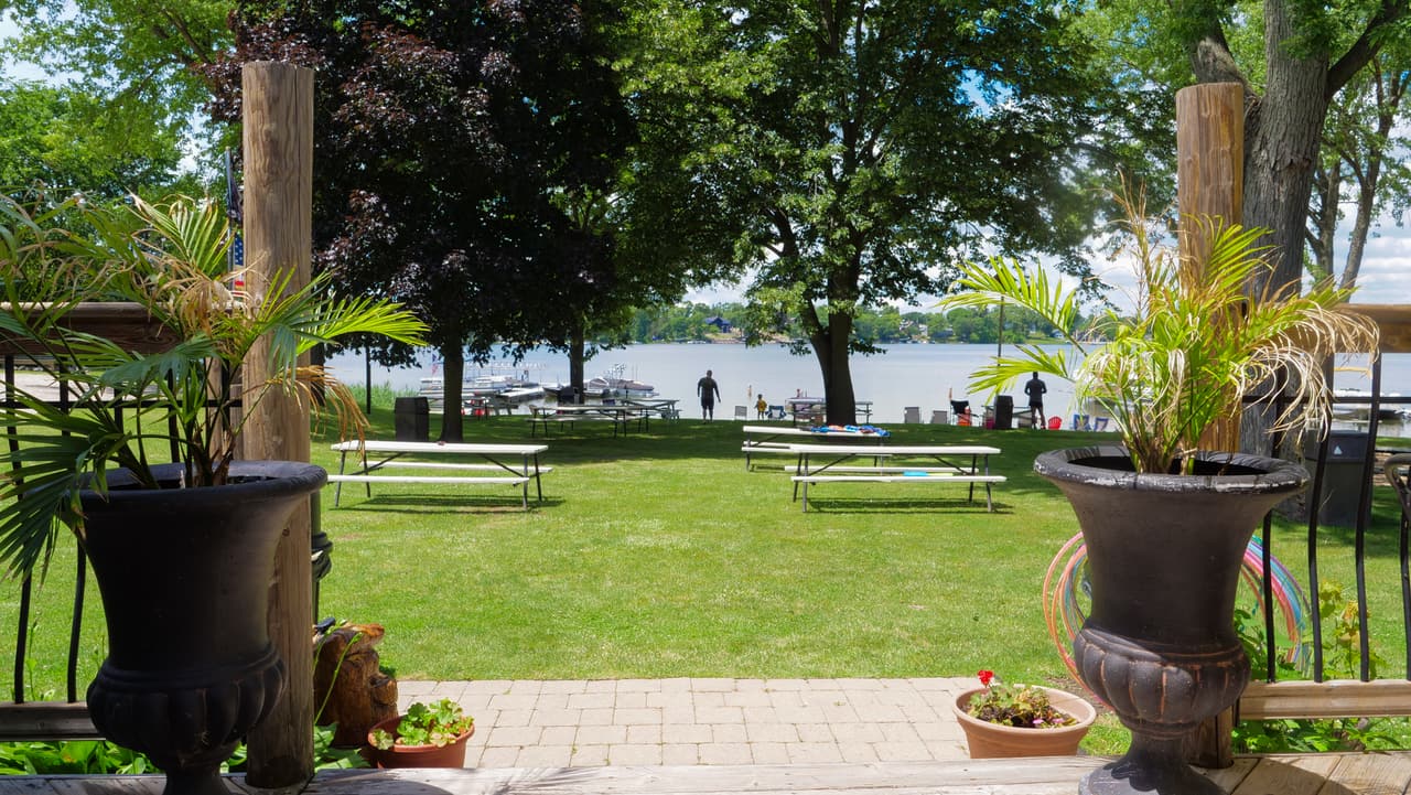 Picnic tables on the lawn with the lake behind them
