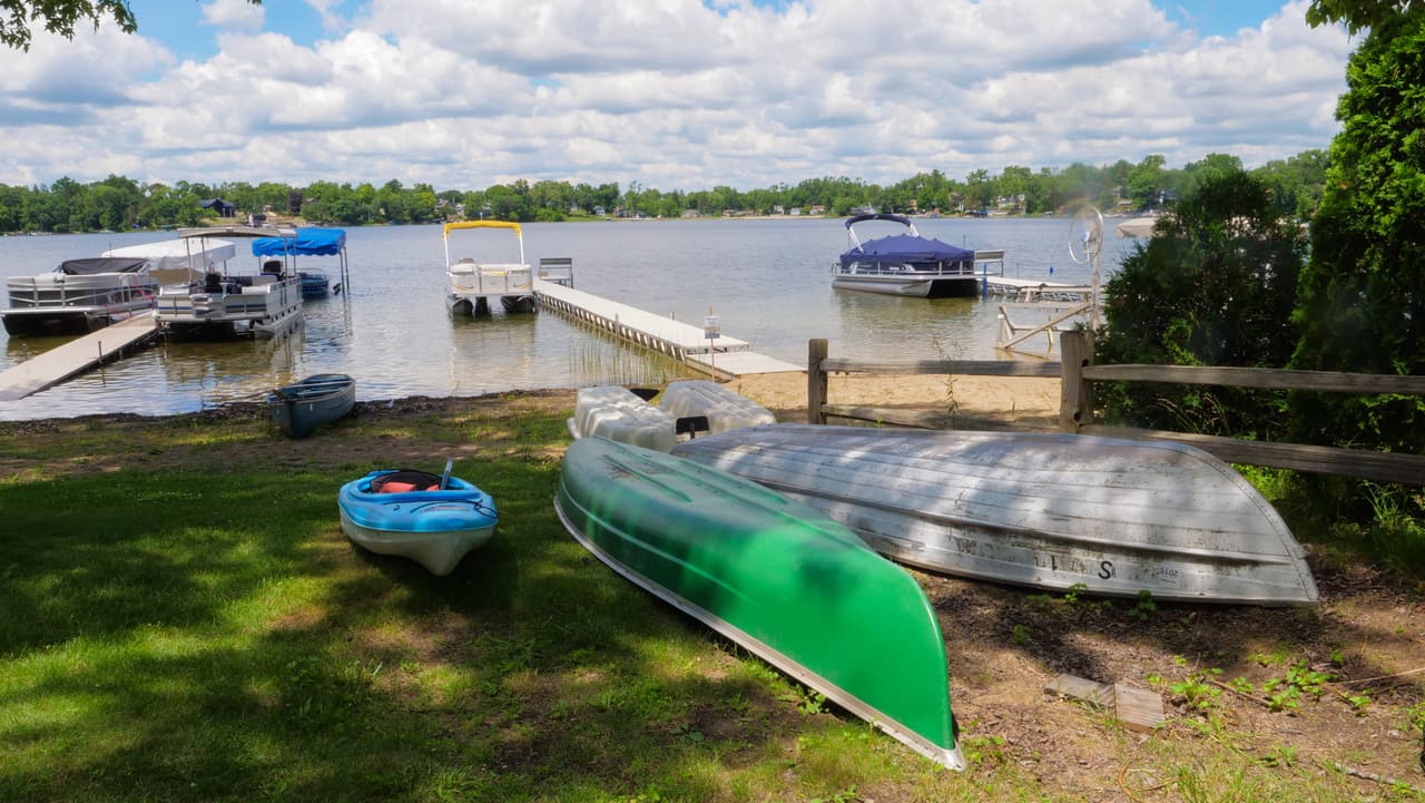 Canoe, kayaks and rowboat on the shore by the piers