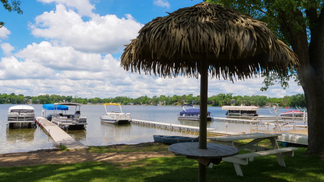 Thatched umbrella over a lakeside picnic table